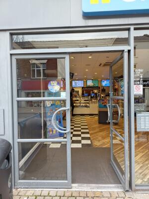 Grey metal-framed glass doors ahead. Push from handles at centre to open.