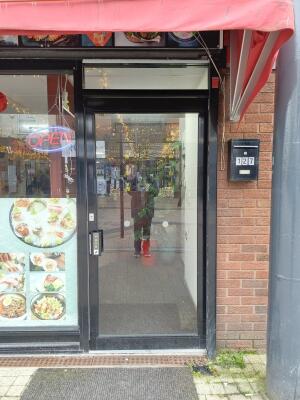 Black metal-framed glass door ahead. Push from handle on left to open.