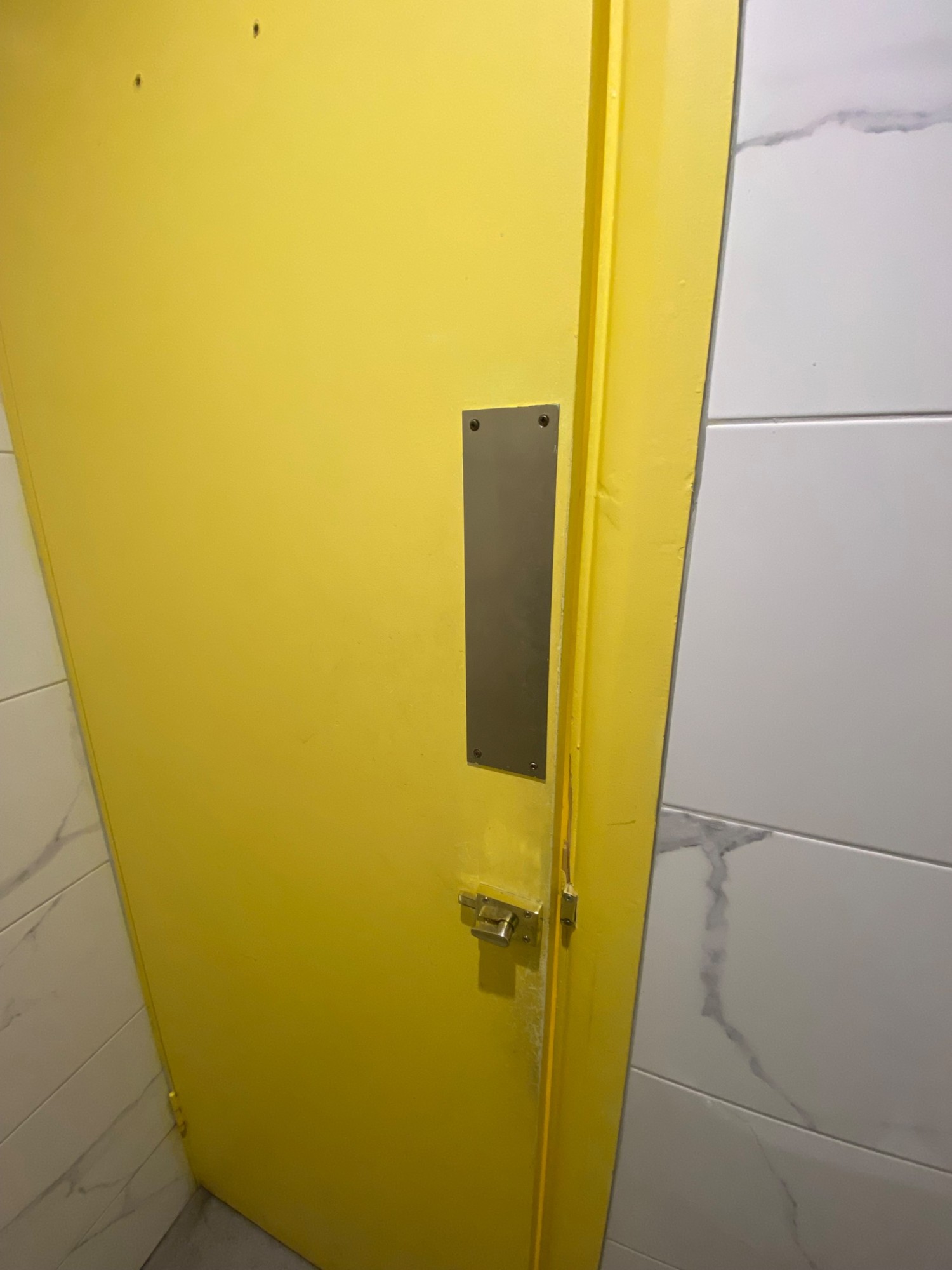 From toilet, facing back at door. Lock in right. Pull to open.