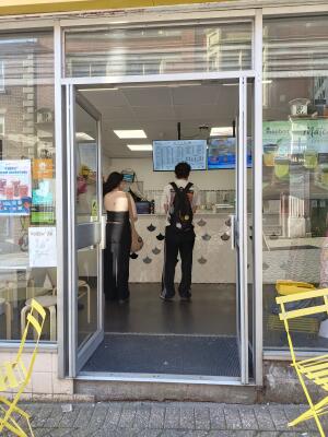 Silver metal-framed glass doors ahead. Push from handle at centre to open.