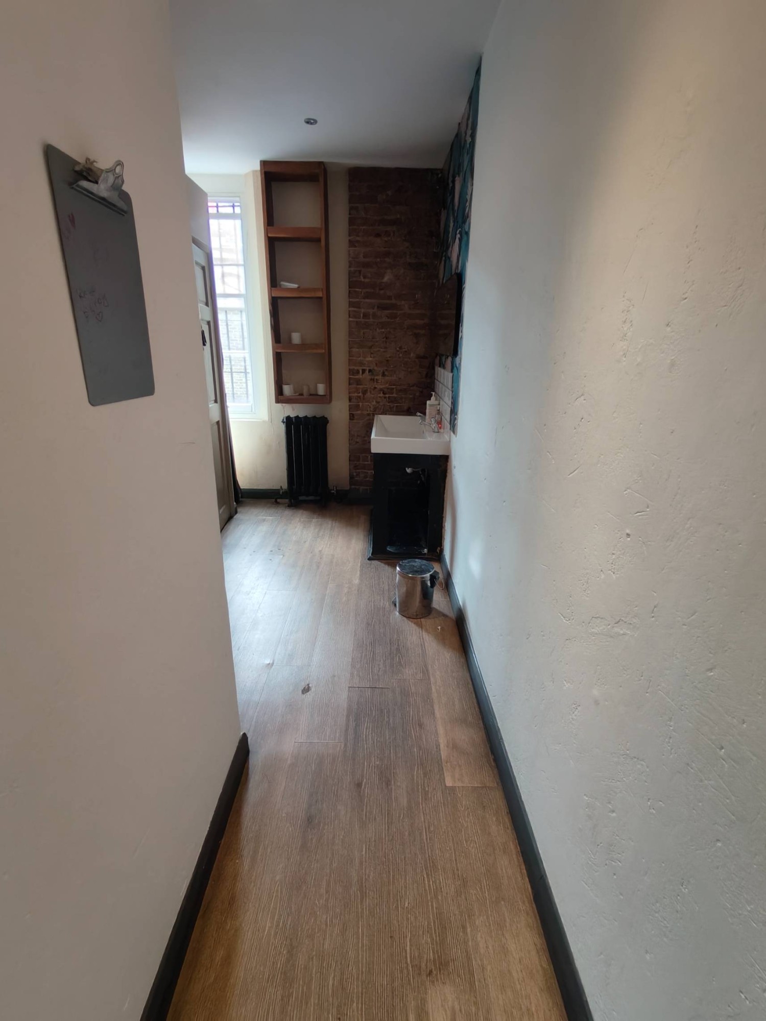 From door facing straight. Path ahead to toilets on left. Wall on left.
