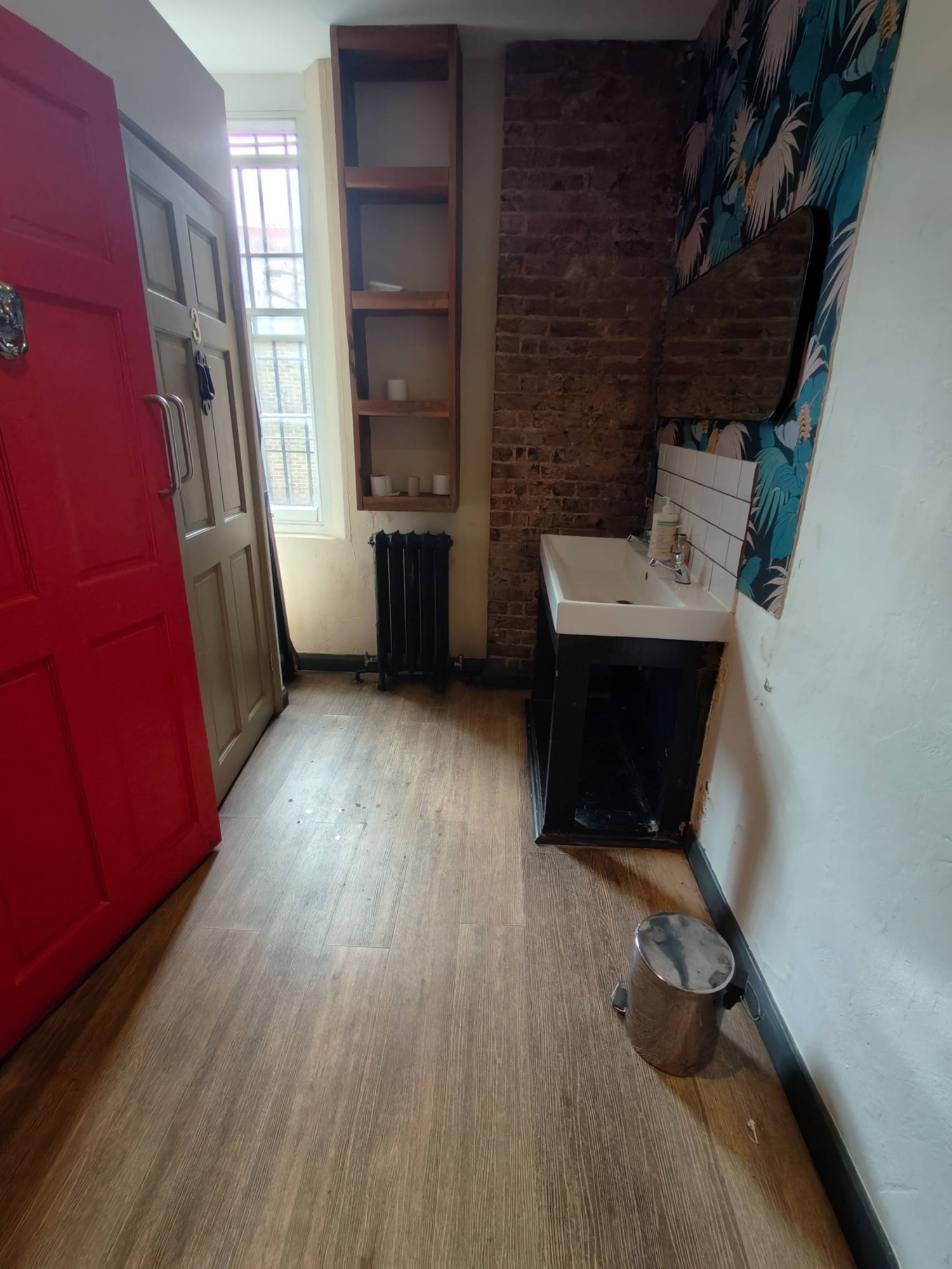 From right of wall facing straight. Sink on back right. Path on left. Toilet cubicles on left.
