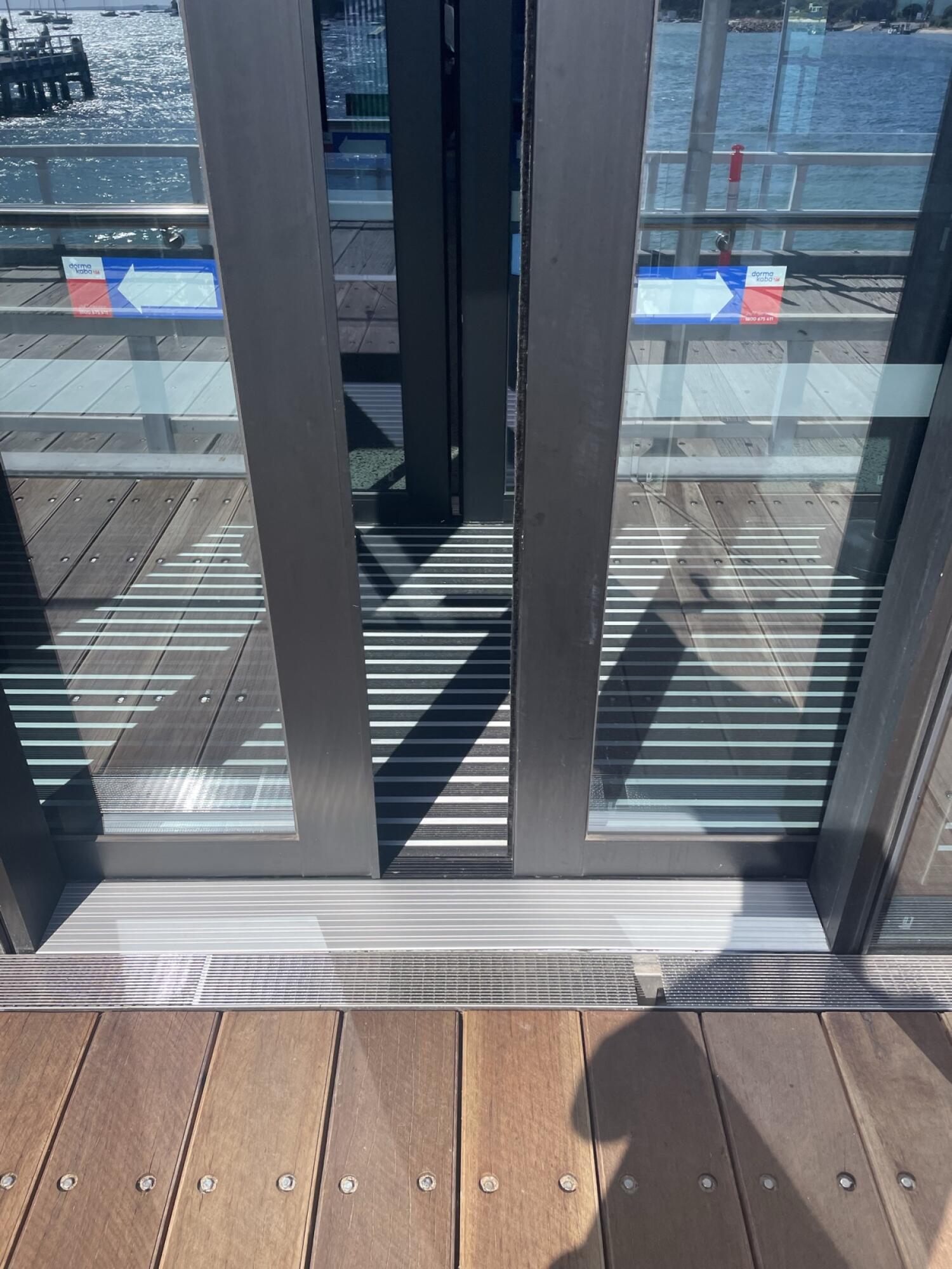 Black metal-framed glass door. Door slides right to open.