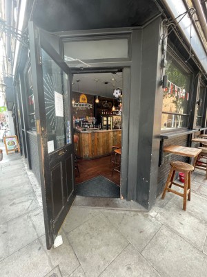 Wooden door with glass panel, handle at right. Pull to open.