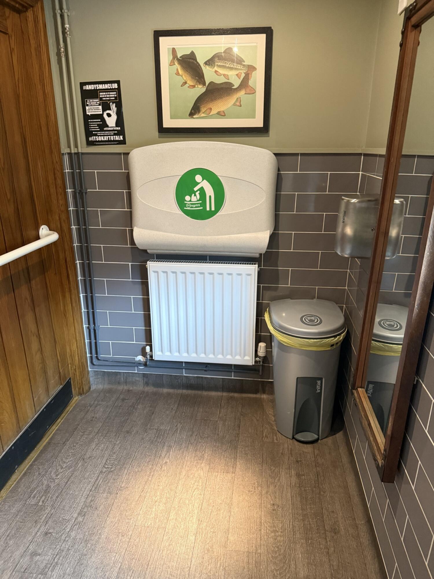 Baby changing station above radiator. Bin to its right.