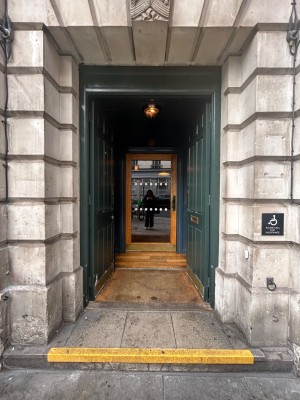 Double preceding teal wooden doors. Push from middle to open.