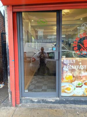 Dark metal-framed glass door ahead. Push metal handle on right to open.