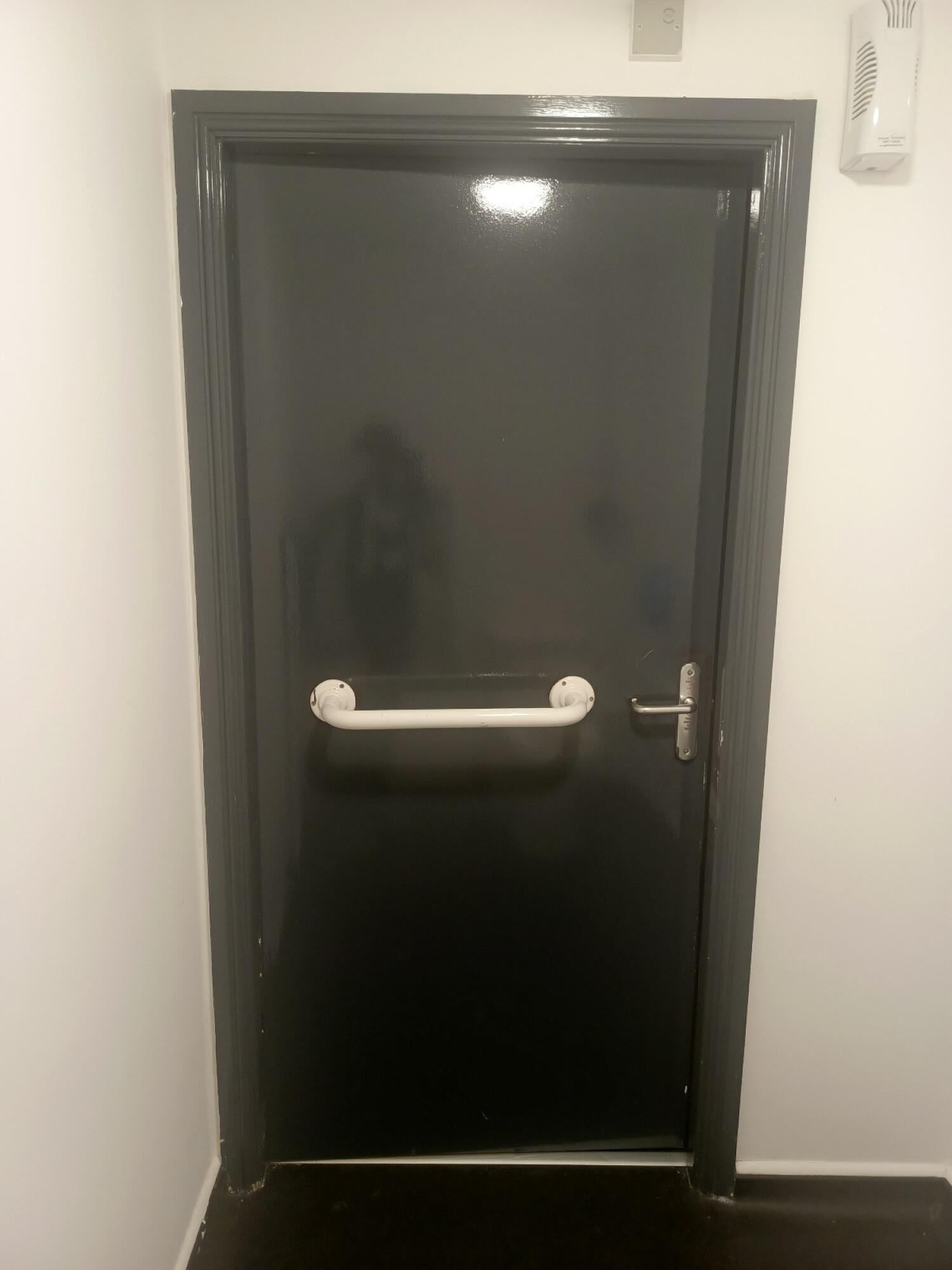 From back of door. Grab rail in centre. Push from handle on right to open.