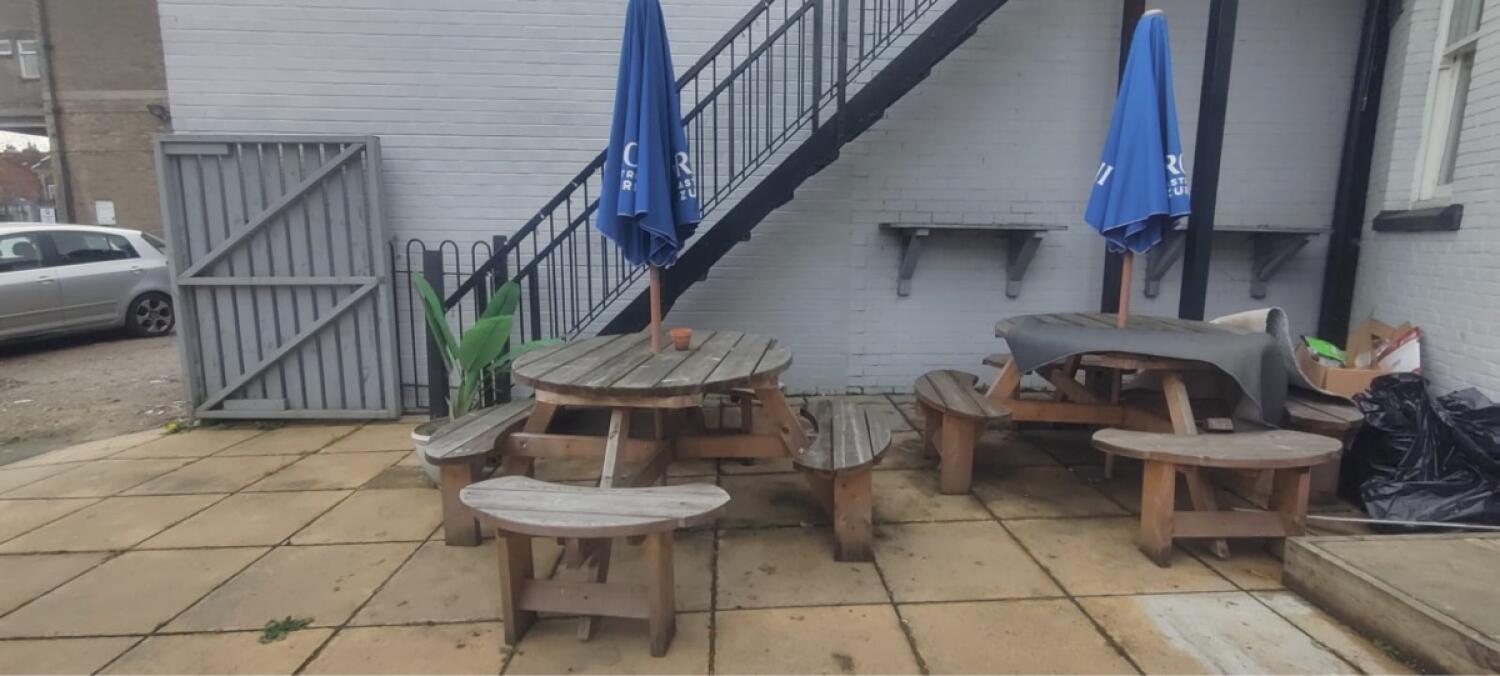 From end of step facing right. Picnic table with parasol along center and right.