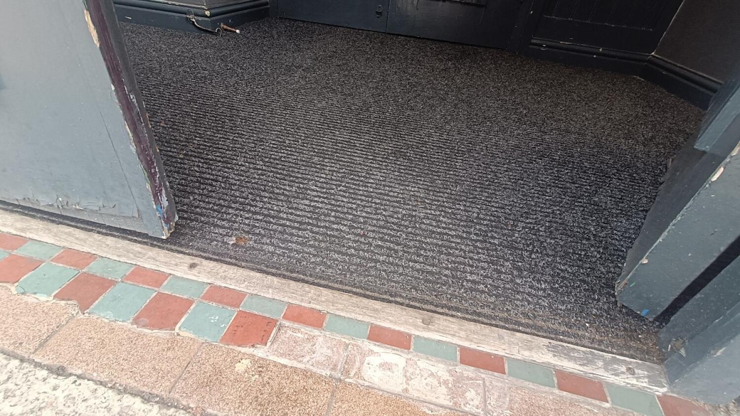Small bump at foot of door followed by doormat.