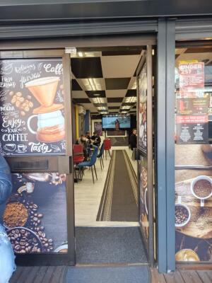 Dark metal-framed glass doors to venue. Push handle on left to open.