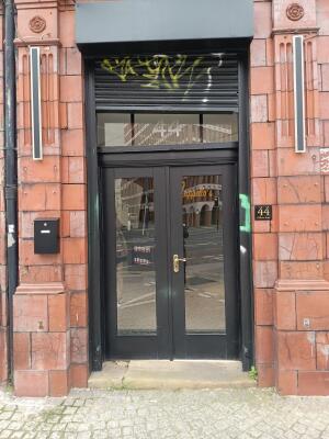 Black metal-framed glass doors ahead. Use handle to open.