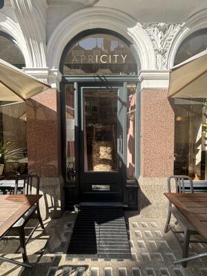 Black wooden framed glass door ahead. Push from handle on right to open.
