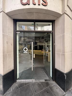 Dark metal-framed glass doors ahead. Push handles in centre to open.