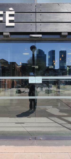 Glass doors with dark metal frame. Automatic doors slide open.