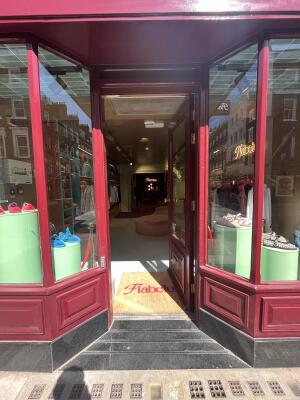Maroon wood-framed glass door. Push on left to open. Doormat inside entrance.