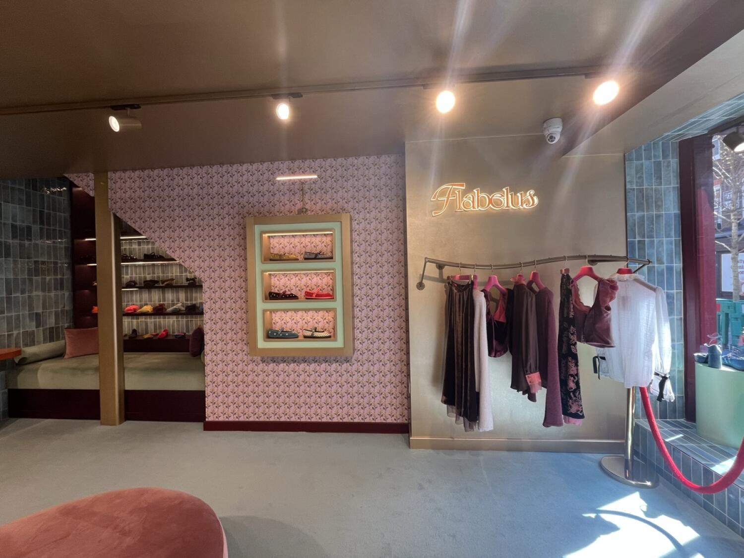 From entrance facing right. Seating and shelves on left. Display shelf and clothing rack center. Window area on the right.