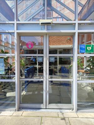 Silver metal-framed glass doors. Doors are automatic.
