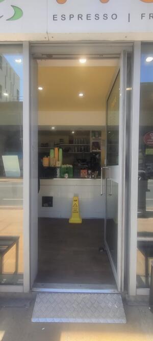 White metal-framed glass door ahead. Use handle to open.