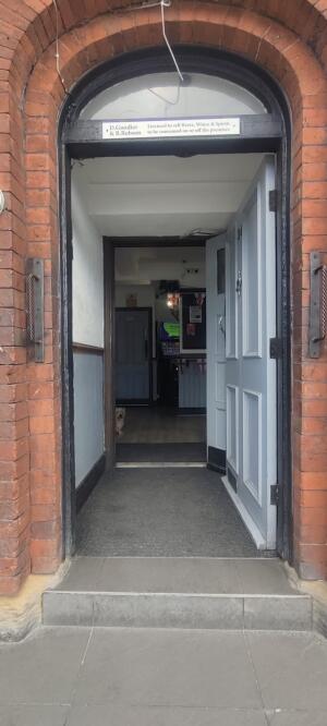 White wooden door ahead. Push metal handle at left to open.
