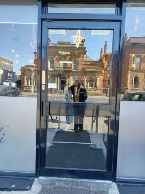 Black framed glass door ahead. Use handle to open.