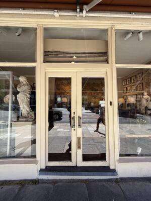 Cream wood-framed glass doors. Push handles in centre to open.