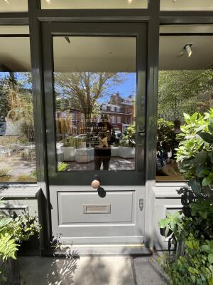 Grey wood-framed glass door. Use handle to open.