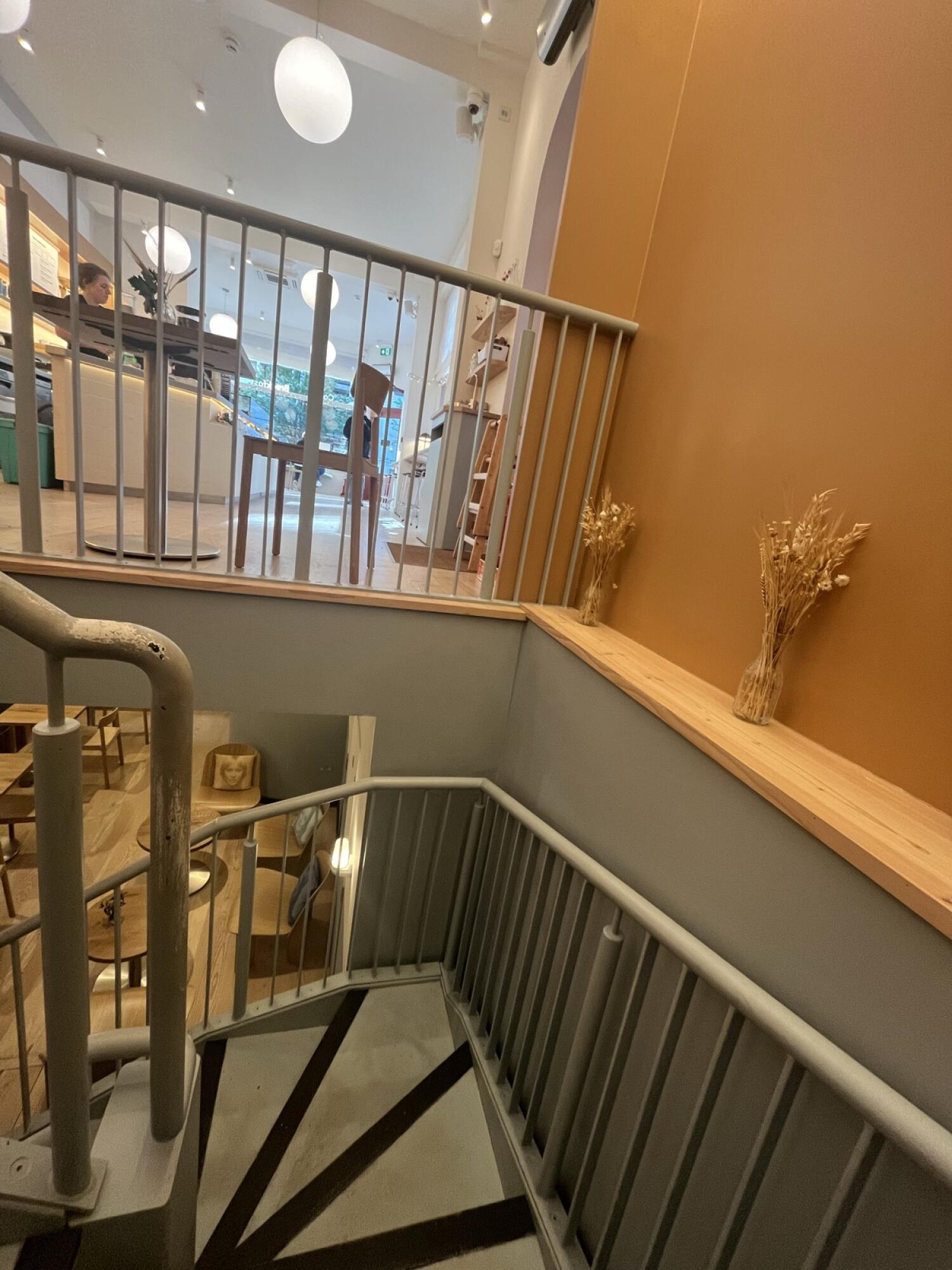 From start of curve facing left. Staircase continues. Handrail along left. Second curve at back.