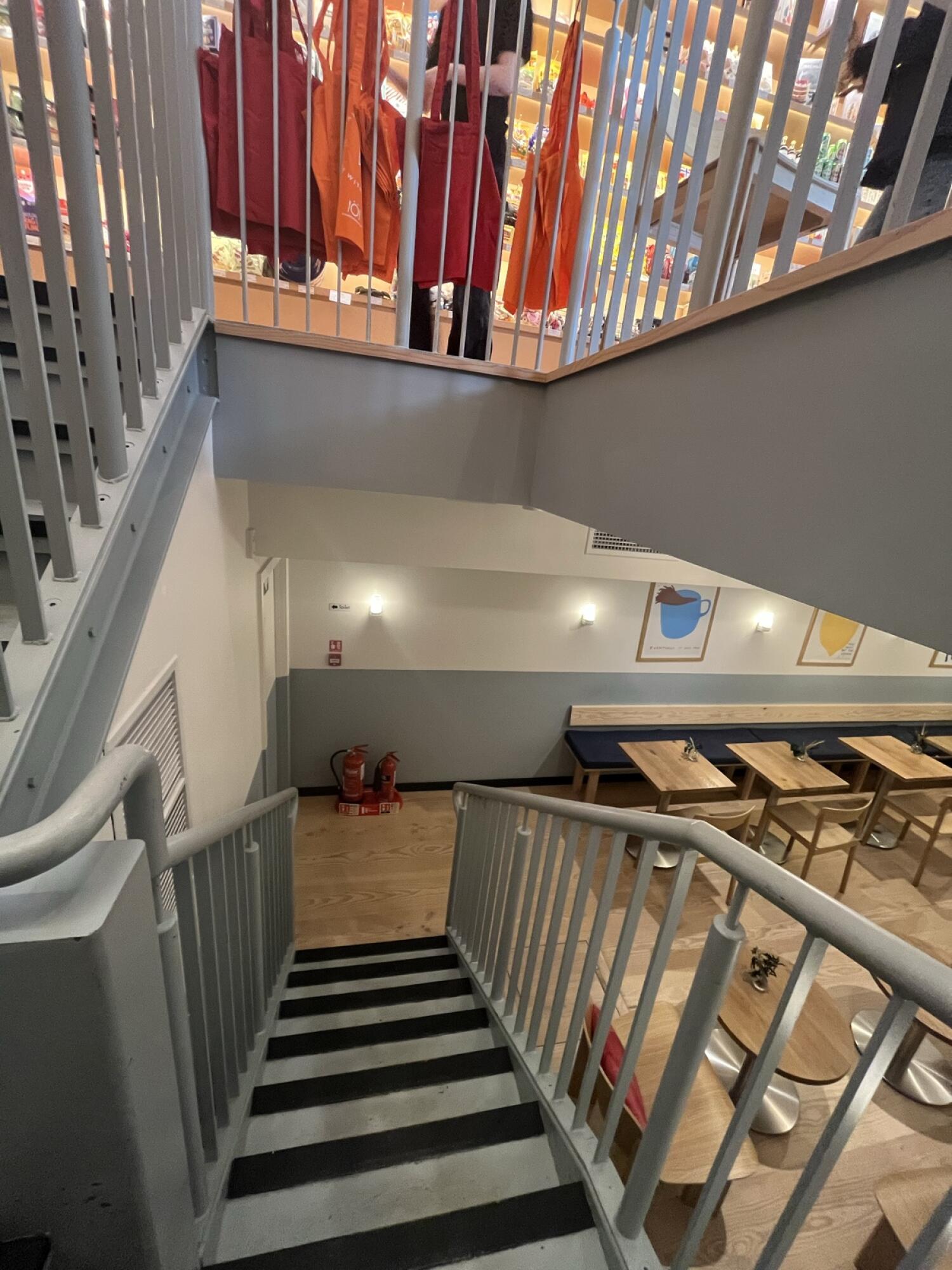 From second curve facing left. Staircase ahead leading down. Handrails along left and right.