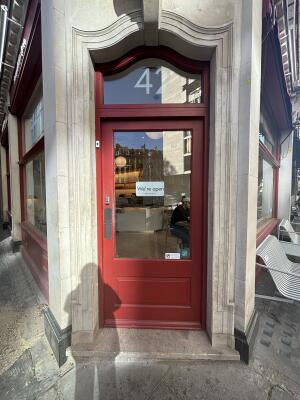 Red wood-framed glass door ahead. Push from left to open.