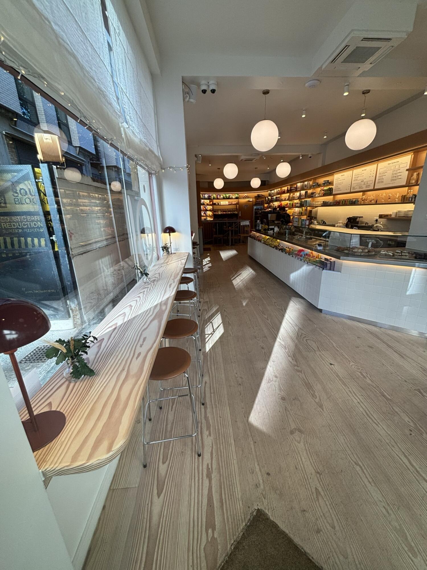 From entrance facing left. High table and stools along left wall. Counter at back right.