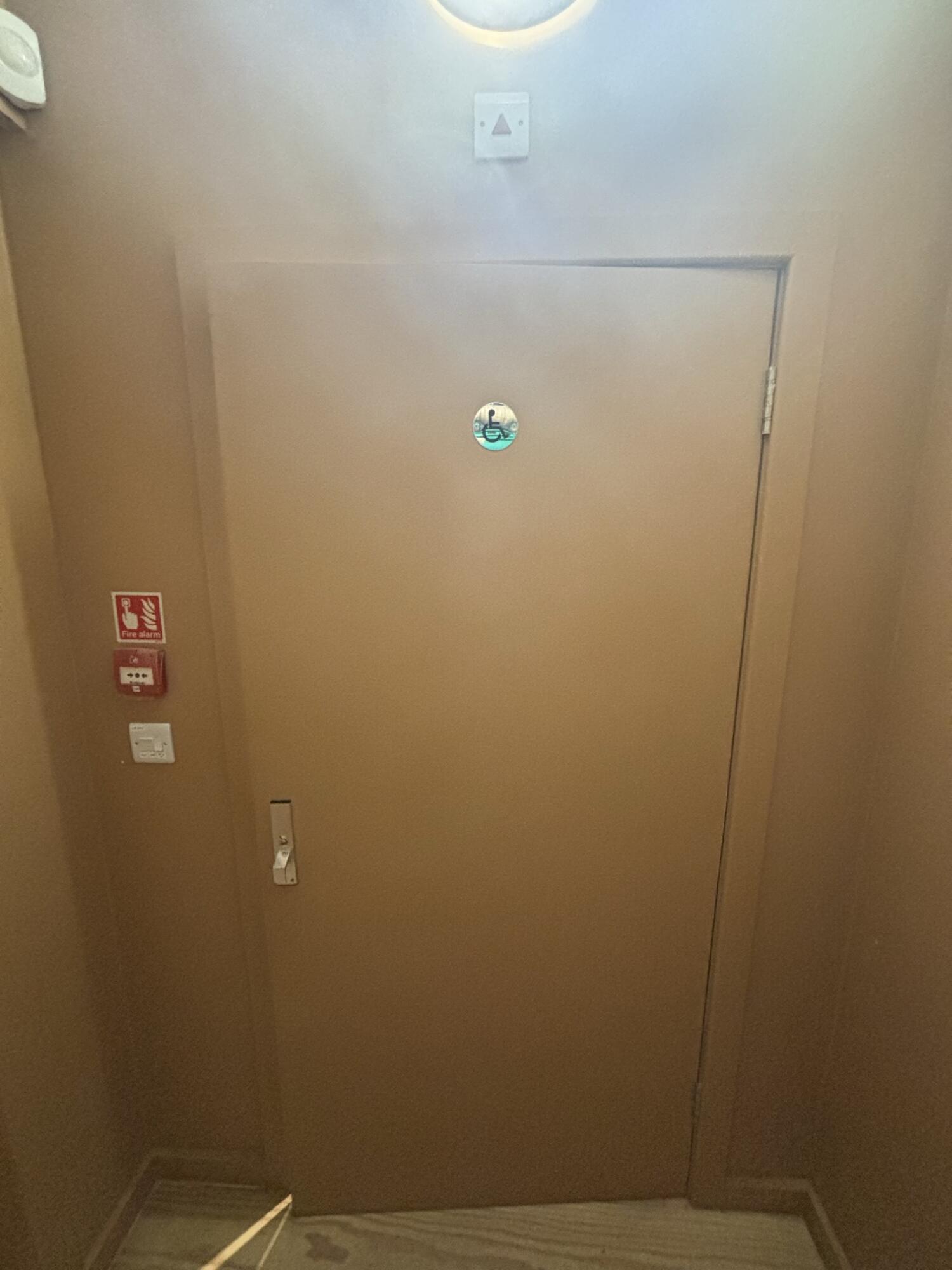 From door facing left. Yellow wooden bathroom door ahead. Pull from left to open.