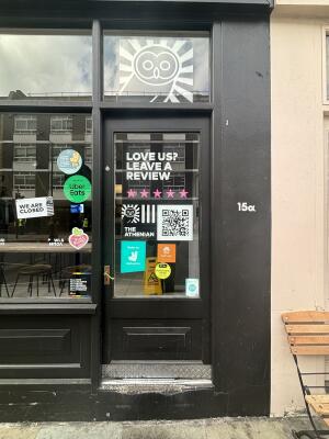 Black metal-framed glass door ahead. Push from handle on left to open.