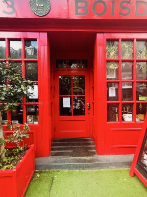 Archway followed by a red wood-framed glass door. Use handle to open.
