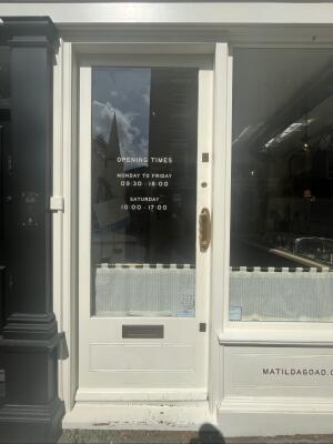 White wood-framed glass door. Use handle to open.