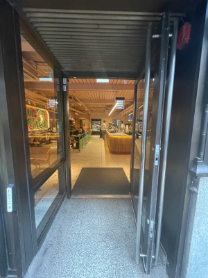 Black glass door with long handle at left, pull to open.
