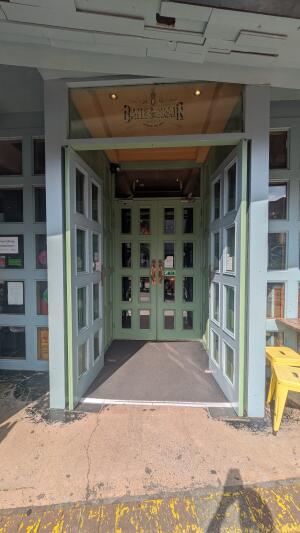 Glass doors with green frame. Push in centre to open.