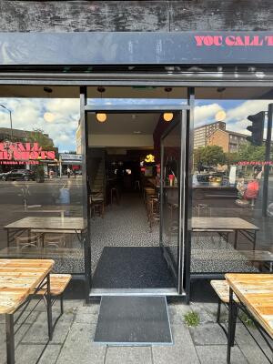 Black metal-framed glass door ahead. Push handle on left to open.