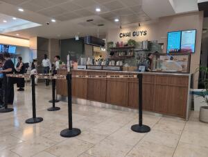 Queue cords along left. Service counter spans centre and right. Display counter on right.