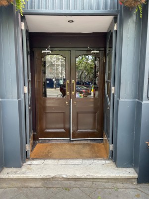 Two sets of doors ahead. First grey double door with glass panel. Push from middle to open. Then brown double door with glass panel. Pull from middle.