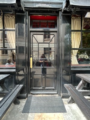 Single black wooden door with glass panel. Push from left to open.