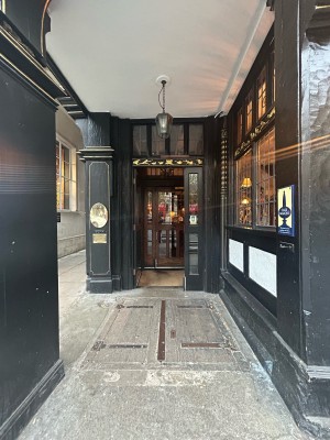 Opening ahead leads to preceding glass door with black frame. Push from right to open.