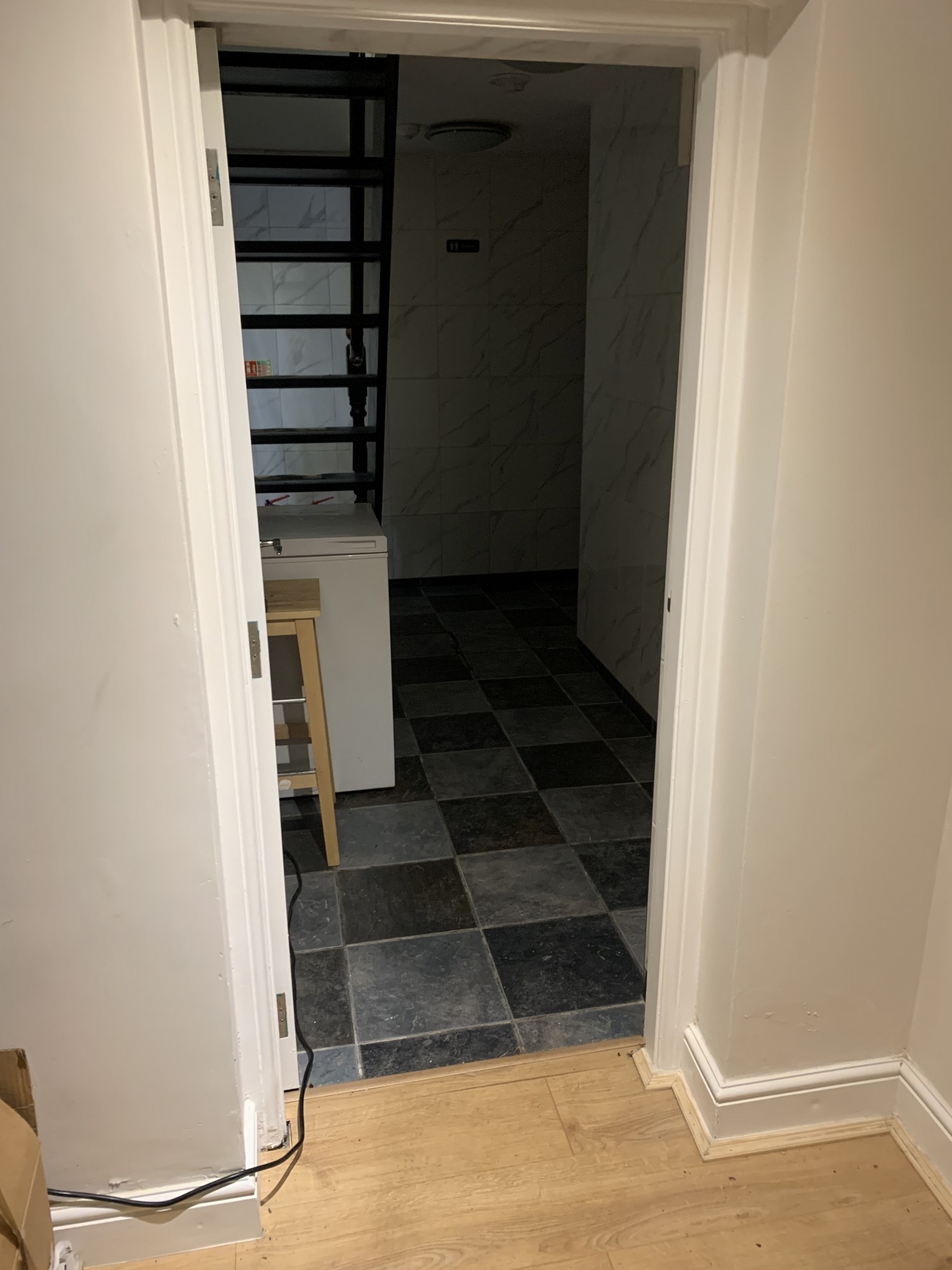 Back right corner, doorway to the bathrooms, through and on the right.