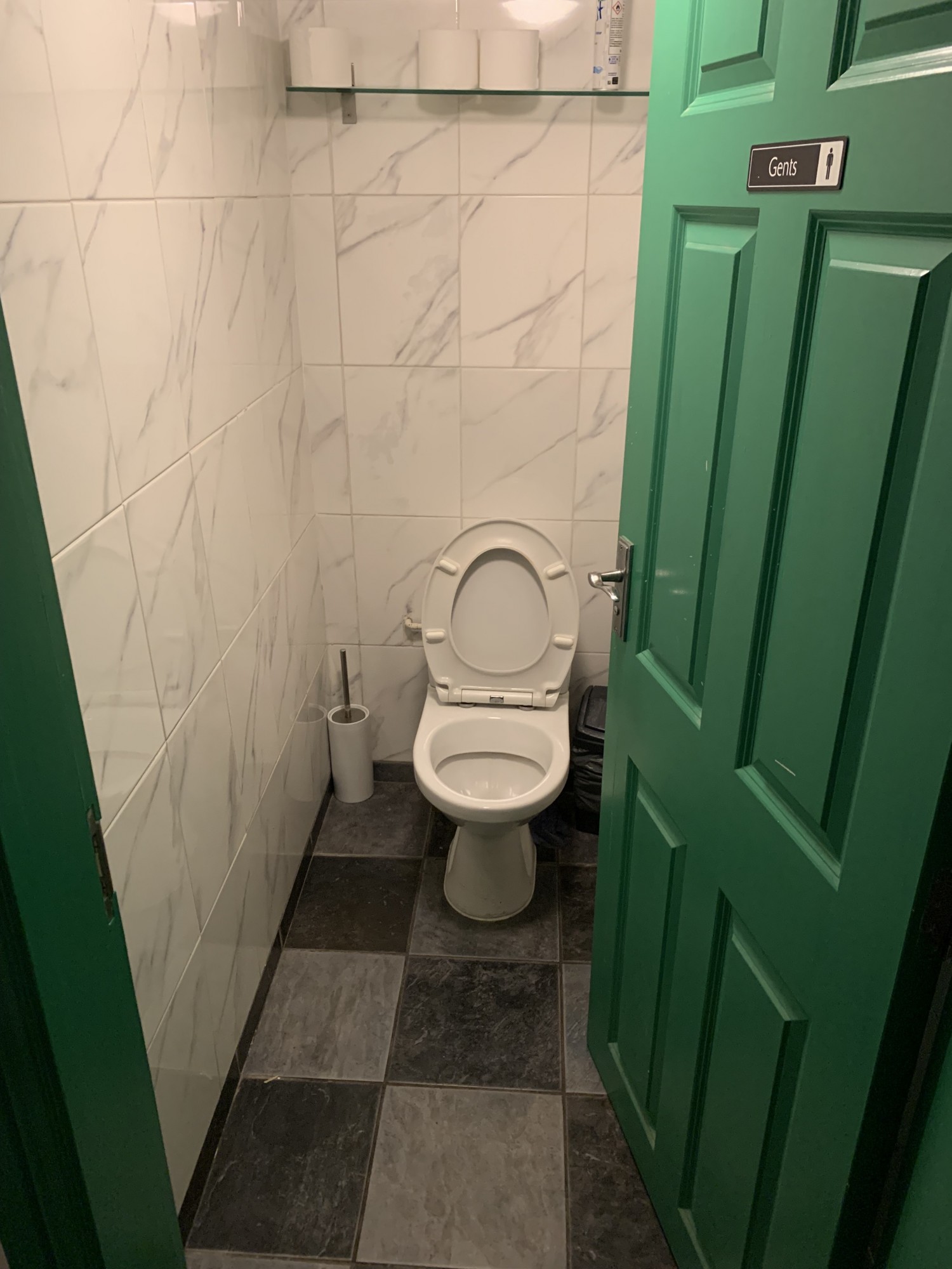 Push cubicle door from the left to open, bathroom along the back wall, bin in the right corner.