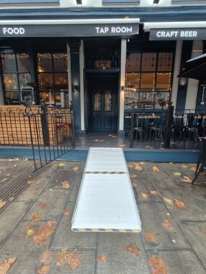 Facing entrance. Black half gate ahead. Pull from right to open. Ramp on request for step on threshold of gate.