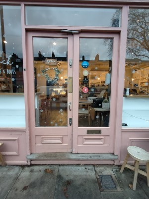 Facing pink framed glass doors. Push from centre to open.