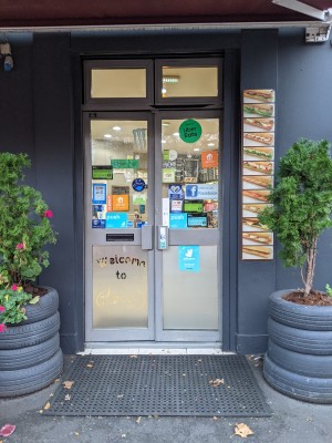 Glass doors with metal frame ahead. Push silver metal handles in centre to open.