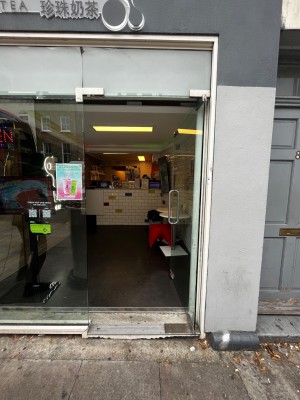 Glass door. Push from left to open. One step up through door.