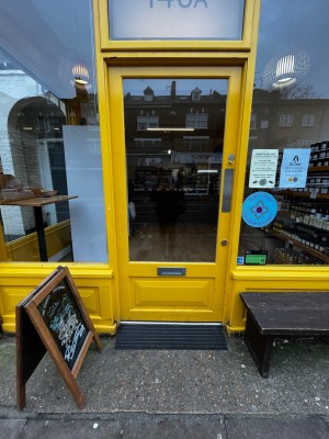 Yellow and glass panelled door. Push from right to open.
