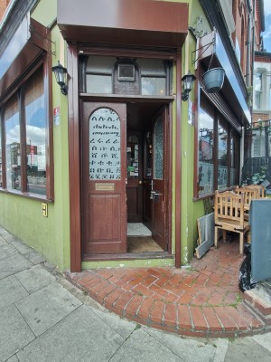 One small step up to wooden framed preceding doors. Push silver handle in centre of right door to open.